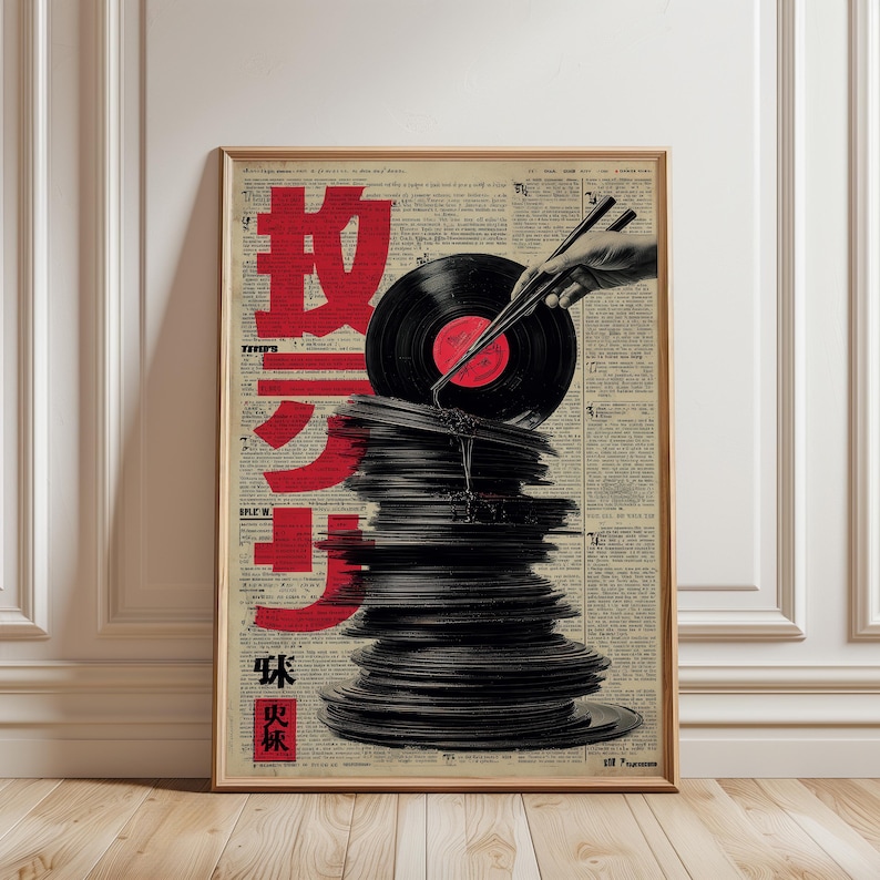 May include: A framed art print featuring a stack of vinyl records with a record being held by chopsticks. The background is a collage of newspaper clippings with red Japanese characters. The print is in a wooden frame.