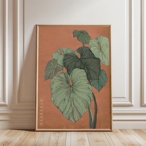 May include: Framed botanical print featuring a detailed illustration of large, green leaves against a warm orange background. The artwork has a vintage aesthetic, with a wooden frame and a touch of Japanese text.