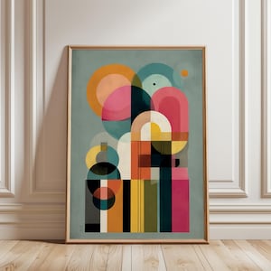 Könnte beinhalten: Abstrakter Kunstdruck in einem Holzrahmen. Das Kunstwerk zeigt ein geometrisches Design mit sich überlappenden Formen in Orange-, Rosa-, Türkis-, Gelb-, Schwarz- und Weißtönen vor einem gedämpften türkisfarbenen Hintergrund. Die Komposition umfasst Kreise, Bögen und rechteckige Formen.