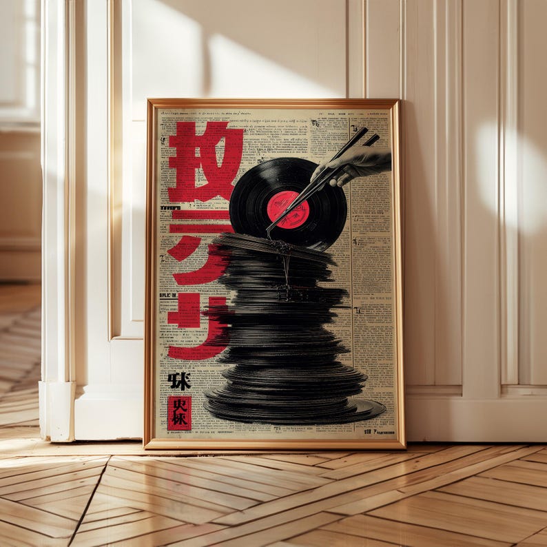 May include: Framed art print featuring a stack of vinyl records with a record being held by chopsticks. The background is a collage of newspaper clippings with red Japanese characters. The frame is gold.