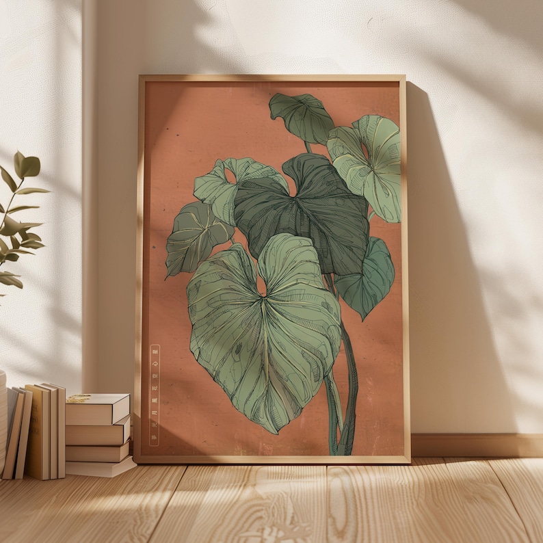 May include: A framed botanical print featuring a detailed illustration of large, green leaves against a muted orange background. The artwork is in a wooden frame and includes the text "MODERN MUSEUM" vertically on the side. The print is displayed on a wooden floor.