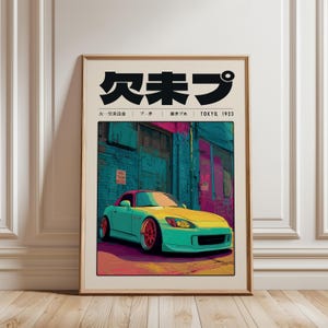 May include: A framed art print featuring a teal and yellow sports car parked in front of a building with teal and pink walls. The print has Japanese text at the top and the words "TOKYO, 1923" at the bottom.