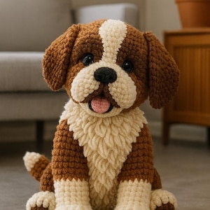 Pode incluir: Um cão de pelúcia feito à mão, de crochê, em posição sentada. O cão apresenta fios marrons e creme, com uma faixa branca na cabeça. Possui olhos pretos, língua rosa e um peito cremoso e fofo.