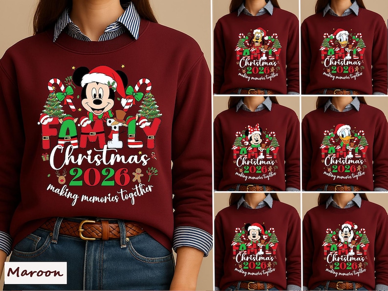 May include: A maroon crewneck sweatshirt featuring a graphic of a Disney character wearing a Santa hat, surrounded by Christmas trees, candy canes, and the text Family Christmas 2026 making memories together in red, green, and white colors.