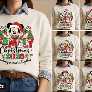 May include: A cream-colored sweatshirt featuring a graphic of Mickey Mouse in a Santa hat, surrounded by Christmas trees, candy canes, and the text "FAMILY Christmas 2026 making memories together." The design includes various Disney characters.