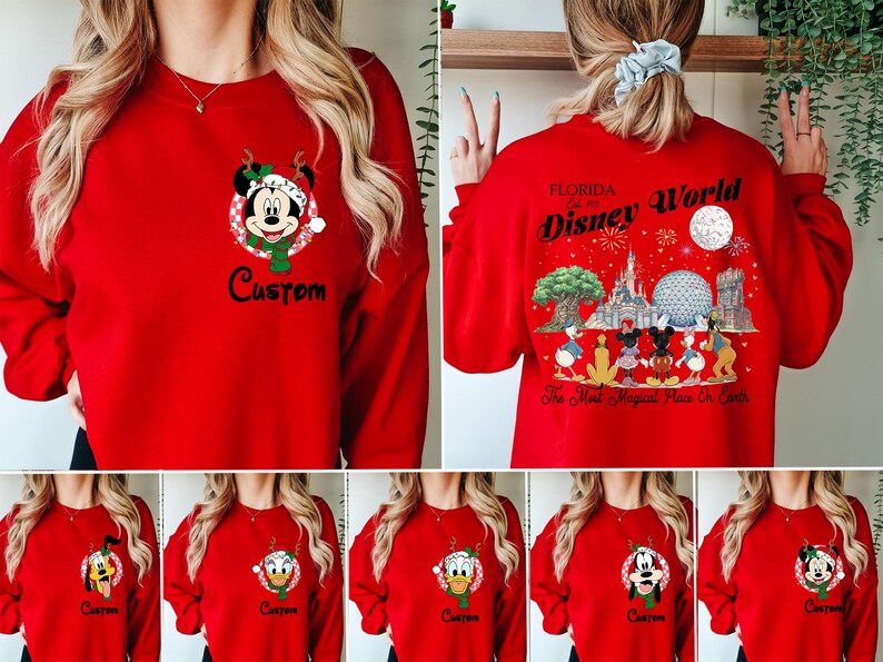 May include: A red crewneck sweatshirt featuring a small graphic of Mickey Mouse in a holiday hat on the left chest with the word Custom below it. The back displays a large Disney World Florida graphic with characters and park landmarks.