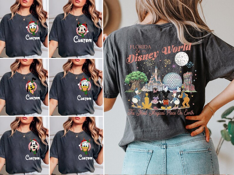 May include: A charcoal grey t-shirt featuring a small circular Disney character graphic on the front left chest with the word Custom below it. The back displays a large colourful illustration of Disney World landmarks and characters with the text Florida Disney World The Most Magical Place On Earth.