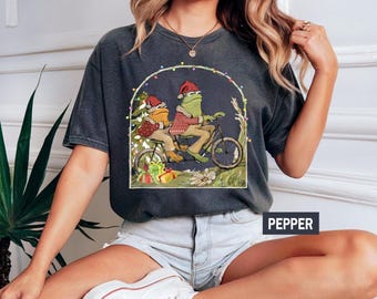 Comfort Colors Frog And Toad Riding A Bike Christmas Shirt,Book Christmas Frog Shirt,Christmas Tee,Christmas Gift,Christmas Frog Toddler Tee