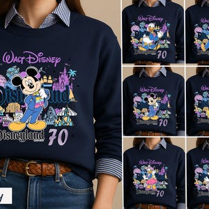 Op de afbeelding: Een marineblauw sweatshirt met ronde hals en een grafische print van het 70-jarig jubileum van Walt Disney Disneyland Resort. Het ontwerp bevat diverse Disney-figuren zoals Mickey Mouse, Donald Duck en Goofy naast iconen van het park.