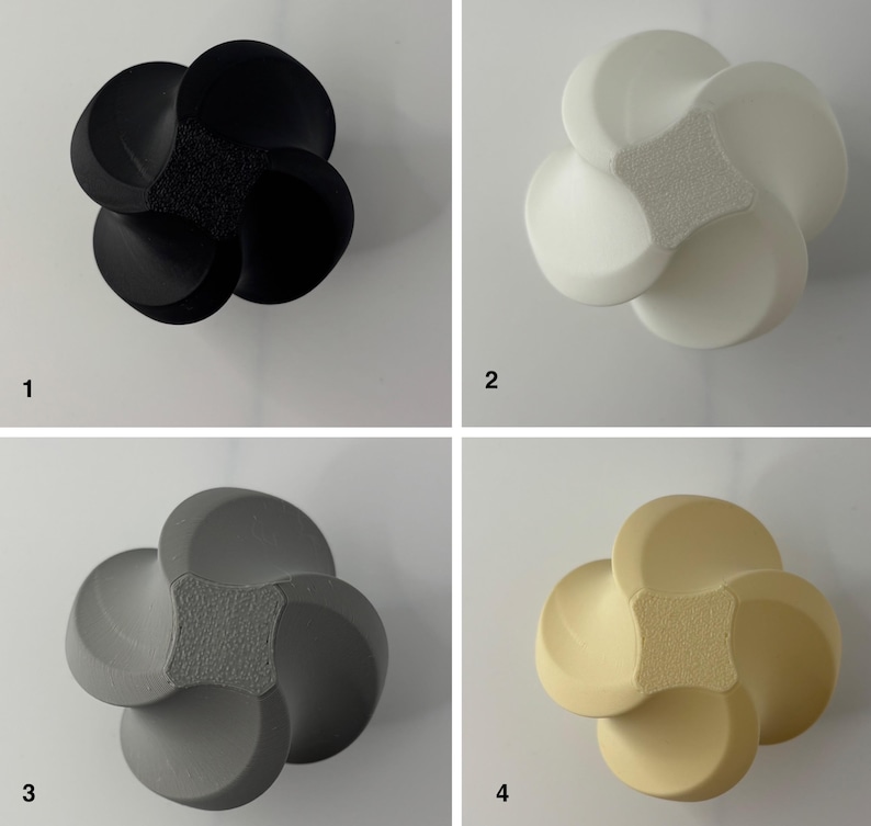 K&ouml;nnte beinhalten: Vier dekorative, bl&uuml;tenf&ouml;rmige Objekte in Schwarz, Wei&szlig;, Grau und Beige. Jedes hat eine strukturierte Mitte und abgerundete Bl&uuml;tenbl&auml;tter. Die Objekte werden vor einem wei&szlig;en Hintergrund pr&auml;sentiert, um ihre Design- und Farbvariationen hervorzuheben.
