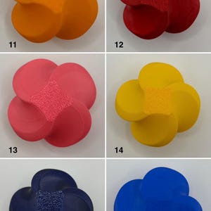 K&ouml;nnte beinhalten: Sechs bl&uuml;tenf&ouml;rmige Dekorationsobjekte in Orange, Rot, Rosa, Gelb, Marineblau und Blau. Jede Blume hat eine strukturierte Mitte und abgerundete Bl&uuml;tenbl&auml;tter, ideal f&uuml;r Heimdekoration oder Bastelprojekte.