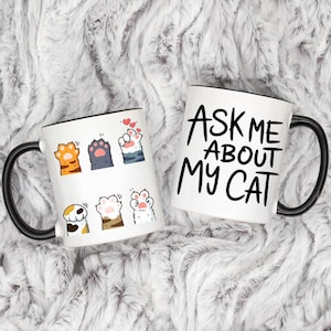 May include: A set of three ceramic mugs with a speckled, matte finish. The mugs are in shades of cream, light gray, and dark gray. Each mug has a simple, minimalist design and a rounded handle.