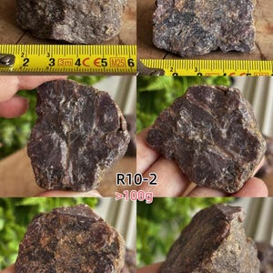 Peut inclure: Un sp&eacute;cimen min&eacute;ral brut de couleur brun-rouge fonc&eacute; avec une surface cristalline textur&eacute;e. Certaines images montrent la pierre &agrave; c&ocirc;t&eacute; d'un m&egrave;tre ruban jaune, indiquant une largeur d'environ 6,5 cm. Le texte indique R10-2 >100g et R7-2.