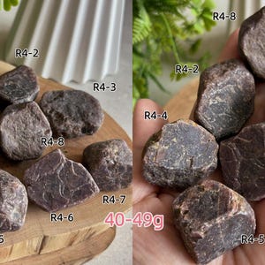 Peut inclure: Une collection de pierres brutes brun-rouge fonc&eacute; aux surfaces irr&eacute;guli&egrave;res et facett&eacute;es. Chaque pierre est &eacute;tiquet&eacute;e avec les codes R4-1 &agrave; R4-8. Le texte 40-49g est visible, indiquant la plage de poids de ces sp&eacute;cimens min&eacute;raux naturels.