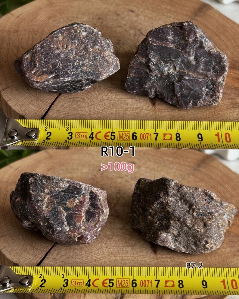 Peut inclure: Deux pierres min&eacute;rales brun fonc&eacute; &agrave; la texture rugueuse sont plac&eacute;es au-dessus d'un m&egrave;tre ruban jaune indiquant une longueur d'environ 10 cm. En dessous, deux autres pierres brun fonc&eacute; sont pr&eacute;sent&eacute;es avec un m&egrave;tre ruban jaune indiquant un poids sup&eacute;rieur &agrave; 100g, &eacute;tiquet&eacute;es R10-1 et R7-2.
