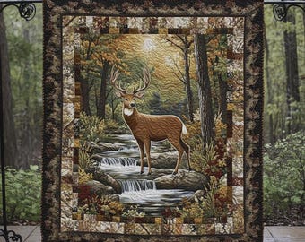 May include: A decorative quilt featuring a majestic deer standing near a waterfall in a forest scene. The quilt has a brown and tan border with a patchwork design. The deer is brown with large antlers, and the forest has autumn colors.
