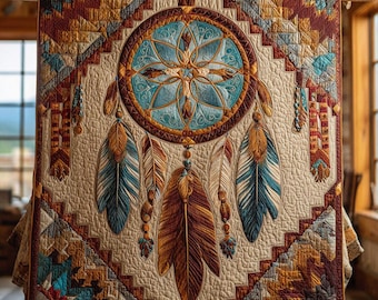 May include: A beige quilt with a large dreamcatcher design. The dreamcatcher features a turquoise center and brown feathers. The quilt has a geometric border in shades of brown, turquoise, and orange. The quilt is displayed on a wooden frame.