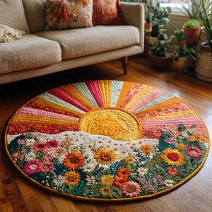 Pode incluir: Um tapete redondo e colorido com um design de nascer do sol. Apresenta um grande sol amarelo e raios radiantes em tons de rosa, laranja e amarelo. A parte inferior do tapete tem um prado floral com várias flores.
