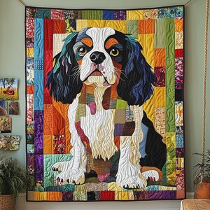 Könnte beinhalten: Ein farbenfrohes Patchwork-Quilt mit einem Cavalier King Charles Spaniel. Das Gesicht des Hundes ist weiß, schwarz und braun, mit einem Patchwork-Körper. Der Hintergrund ist eine Mischung aus bunten Quadraten, die ein einzigartiges Textilkunstwerk schaffen.