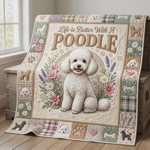 May include: A cream-coloured quilt featuring a central illustration of a white poodle surrounded by flowers. The text reads Life is Better With A POODLE. The border consists of patchwork squares displaying poodle silhouettes, paw prints, and bones.