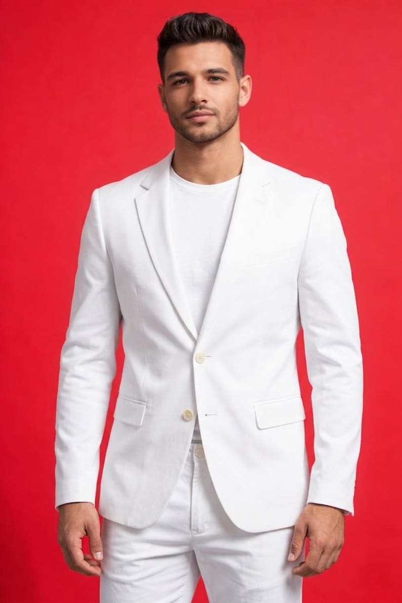 May include: A white suit, consisting of a blazer and pants, is shown against a red background. The blazer has a single-button closure and a notched lapel. The outfit is completed with a white t-shirt.