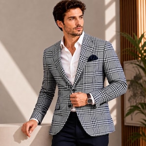 May include: A navy and white plaid blazer with a white dress shirt and a navy pocket square. The blazer has a two-button closure and a classic fit. A brown leather watch is visible on the wrist. The overall style is business casual.