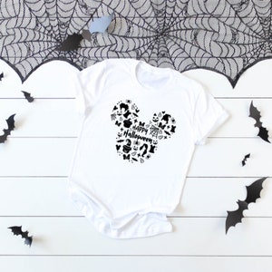 May include: White t-shirt with a black Mickey Mouse head design. The head is filled with Halloween icons and the text "Happy Halloween".