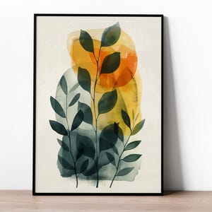 Könnte beinhalten: Ein gerahmter Wandkunstdruck mit einer Aquarellillustration von drei dunkelgrünen Blattzweigen, die über abstrakten, durchscheinenden Formen in Goldgelb, Orange und gedämpftem Blaugrün auf einem hellen cremefarbenen Hintergrund liegen.