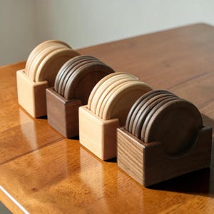 May include: Four sets of circular wooden coasters, each housed in a matching square wooden holder. The coasters and holders alternate between light-toned wood and dark-toned wood, arranged in a diagonal row on a polished wooden surface.