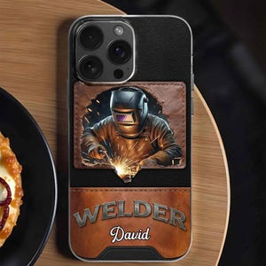 May include: Black phone case with a brown leather wallet design. The wallet features an illustration of a welder with sparks and the word "WELDER" above the name "David".