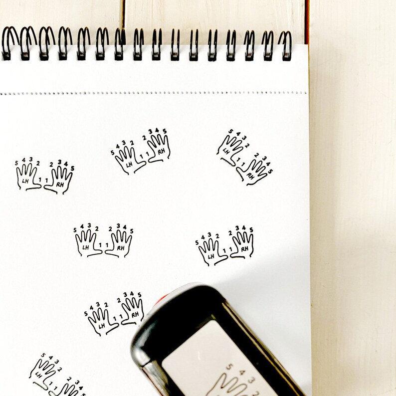 May include: A black and white self-inking stamp with the text "5 4 3 2 1 2 3 4 5 LH RH" and a graphic of two hands with numbered fingers.