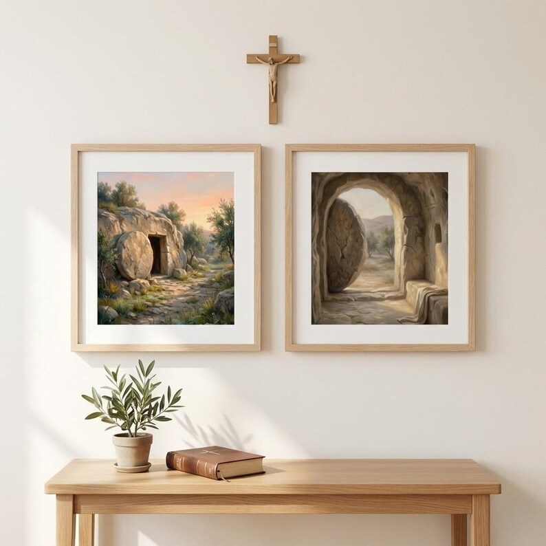 May include: Two framed art prints depicting a religious scene. One shows a tomb with an open door, the other a tomb with a large stone rolled away. A wooden cross hangs above the frames. A small plant and a book sit on a wooden table.