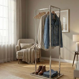 May include: A chrome clothing rack with a light-colored sweater, a denim jacket, and a pair of brown leather boots. The rack also holds a pair of folded blue jeans. The rack is in a room with a neutral color scheme.