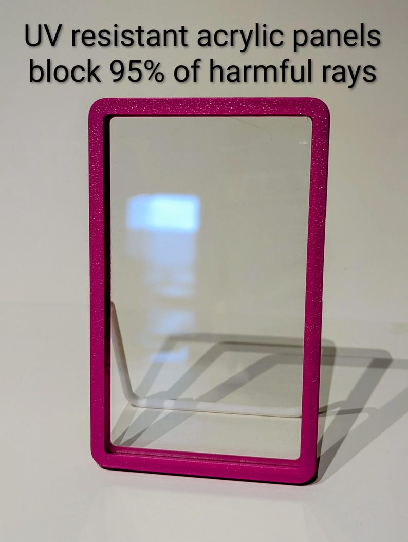May include: A rectangular, magenta-colored frame with rounded corners, holding a clear acrylic panel. The text at the top reads "UV resistant acrylic panels block 95% of harmful rays."