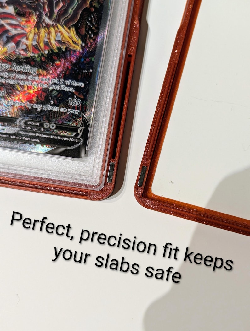 May include: A red-brown protective case for a trading card, with the card partially visible. The card has a colorful design with the number 160 visible. Text on the case reads "Perfect, precision fit keeps your slabs safe."