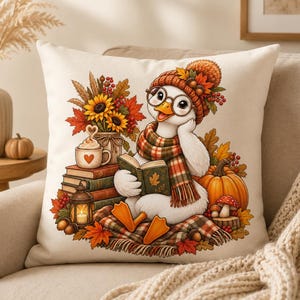 May include: A square throw pillow featuring a white background with a central illustration of a white duck wearing a knit hat, glasses, and a plaid scarf. The duck is reading a book surrounded by sunflowers, autumn leaves, a pumpkin, and a lantern.