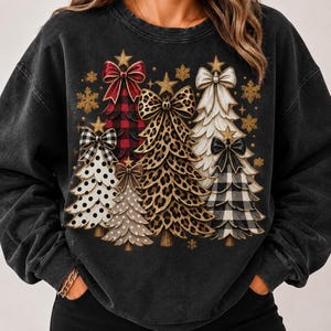 Puede incluir: Una sudadera negra con lavado ácido que presenta un estampado gráfico de cinco árboles de Navidad estilizados. Los árboles muestran varios patrones, incluyendo cuadros rojos, estampado de leopardo, lunares blancos y cuadros vichy.