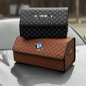 Może przedstawiać: Dwa pikowane organizery do przechowywania, jeden czarny i jeden brązowy, są ułożone jeden na drugim. Organizery mają wz&oacute;r w romby z białymi przeszyciami. Czarny organizer jest na g&oacute;rze, a brązowy na dole.