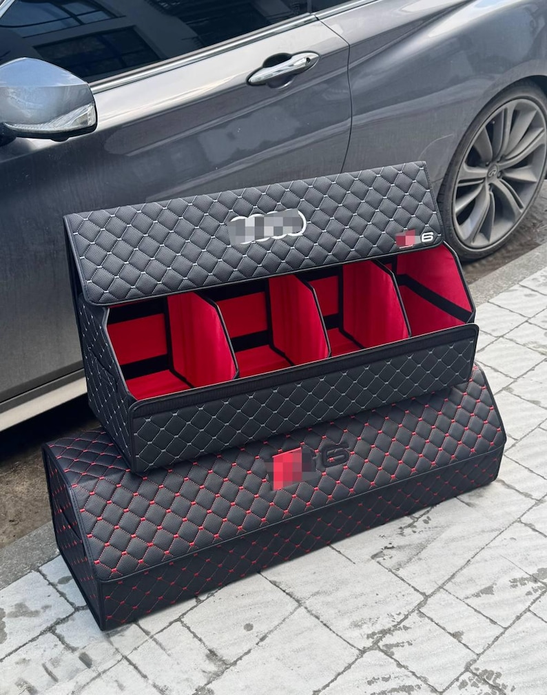 Puede incluir: Organizador de coche negro con interior rojo y costuras de diamante. El organizador tiene m&uacute;ltiples compartimentos y una tapa. El exterior presenta un logotipo y el n&uacute;mero 6.