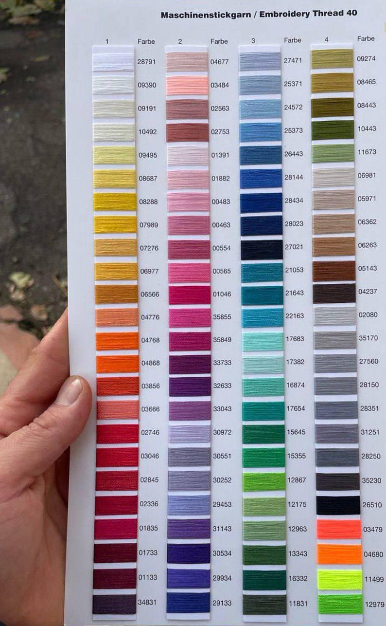 May include: Color chart for embroidery thread with a variety of colors, including white, pink, blue, green, and orange. The chart is labeled with numbers and color codes, ideal for craft projects.