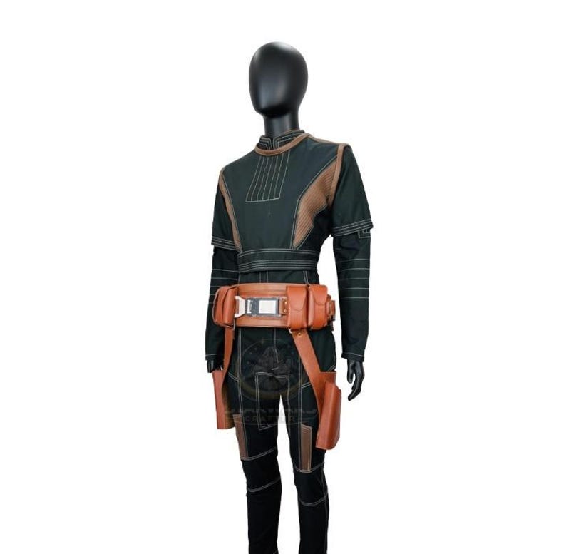 May include: A dark green long-sleeved jumpsuit featuring textured brown panels on the chest and legs, accented with white stitching. A tan utility belt with multiple pouches and a central metallic buckle is worn around the waist of the garment.