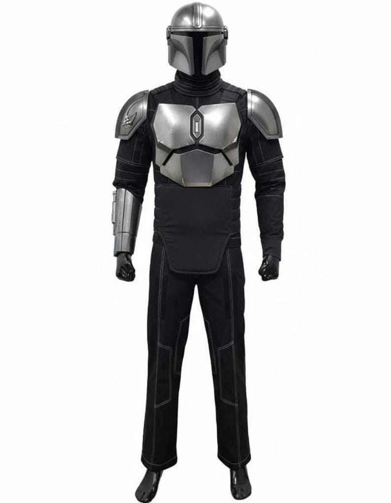 May include: A full-body costume featuring a silver helmet and chest armor. The costume includes black pants and a long-sleeved shirt with silver accents. The armor has a metallic finish, and the outfit is designed to resemble a character from a science fiction series.
