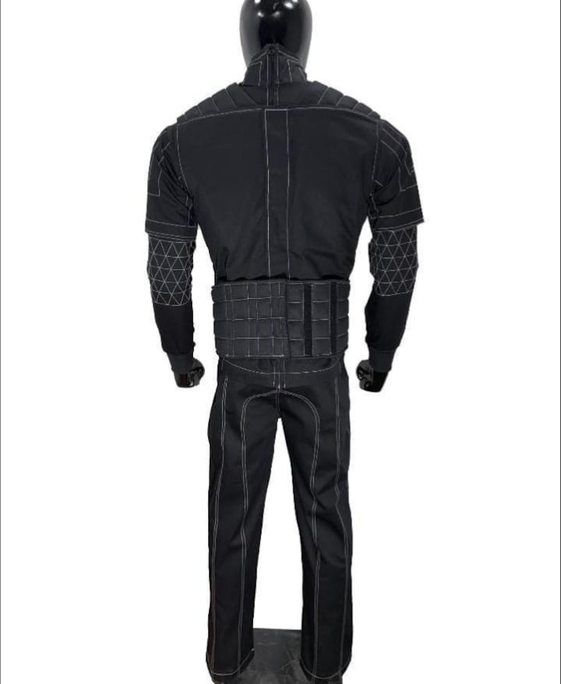 May include: A black tactical suit displayed on a mannequin. The suit features white stitching, a quilted vest, and geometric patterns on the sleeves. The pants have a straight leg design. The mannequin has a black head.