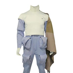 May include: A light blue jumpsuit featuring a white high-neck bodice, long sleeves, and four large cargo-style pockets on the legs. A tan and brown color-blocked fabric panel drapes from the right shoulder, extending down the side of the garment.
