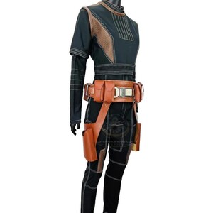 May include: A black long-sleeved top and matching pants set featuring brown leather-like accents on the shoulders and torso. A brown utility belt with multiple pouches and a holster attachment is worn around the waist over the dark clothing.