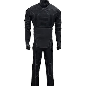 May include: Black tactical suit displayed on a mannequin. The suit includes a long-sleeved top with reinforced panels and white stitching, and matching pants. The mannequin is black, and the background is white.