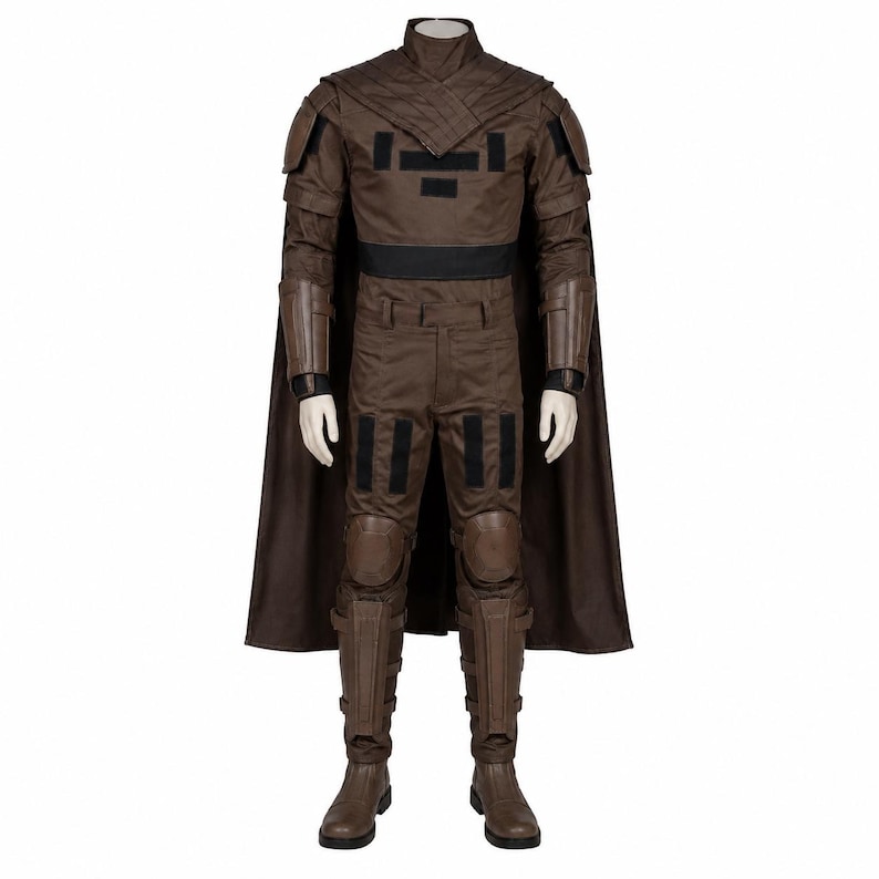 May include: A brown costume with a high collar, shoulder pads, and a black belt. The outfit includes matching pants, boots, and a cape. The costume has black accents and is designed for a character.