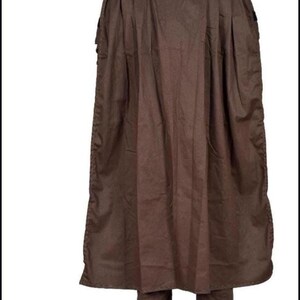 May include: A brown outfit consisting of a long cape and matching pants. The cape has a high collar and extends to the knees. The pants are straight-legged. The outfit is made of a solid, matte fabric.