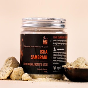 Puede incluir: Un frasco de Isha Sambrani, una resina aromática pura y natural, con el texto "El antiguo arte de limpiar un espacio". El frasco está etiquetado "Made in Bharat" y contiene 100 g de producto. Junto al frasco hay trozos de resina y un cuenco de madera.