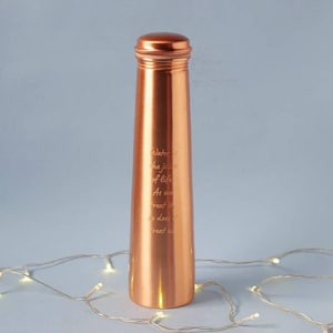 May include: A copper water bottle with a screw-on lid. The bottle is cylindrical and has engraved text: "Water is the juice of life. As we treat it, so does it treat us." The bottle is made of copper.